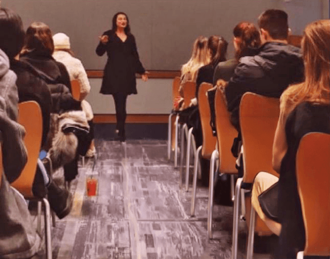 Dr. Nelli Gluzman speaking to an audience in a classroom setting